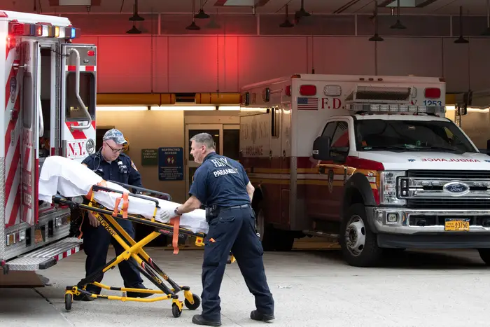 Paramedics place an empty collapsible wheeled stretcher into an ambulance after delivering a patient into the emergency room at NewYork-Presbyterian Lower Manhattan Hospital, in New York.